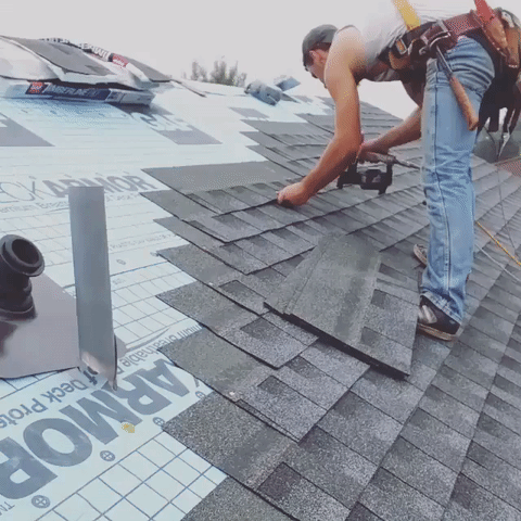 Man on roof installing shingles