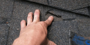 Hand pointing to roof damage