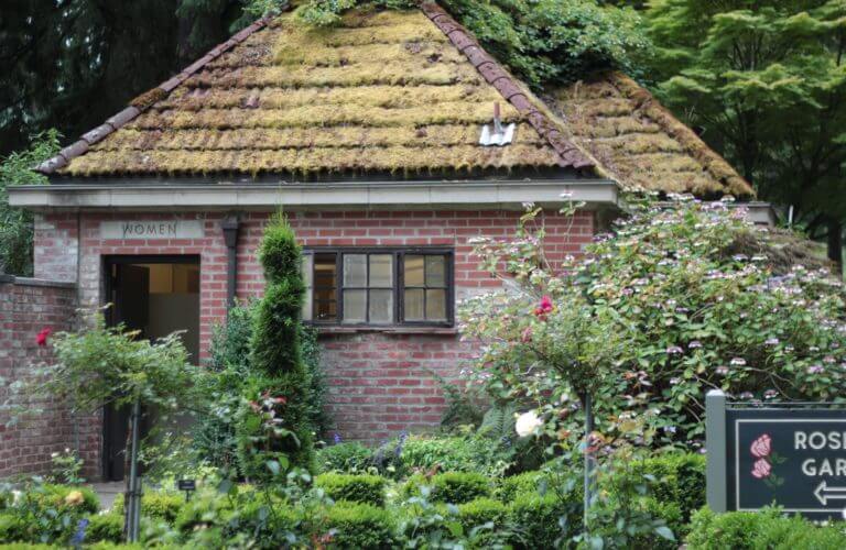 red brick bathroom building with moss on roof