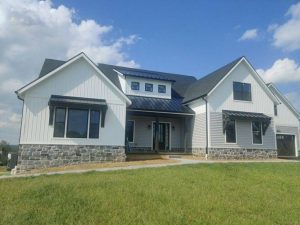 charcoal shingle and metal roof installed on this new construction home by joyland roofing