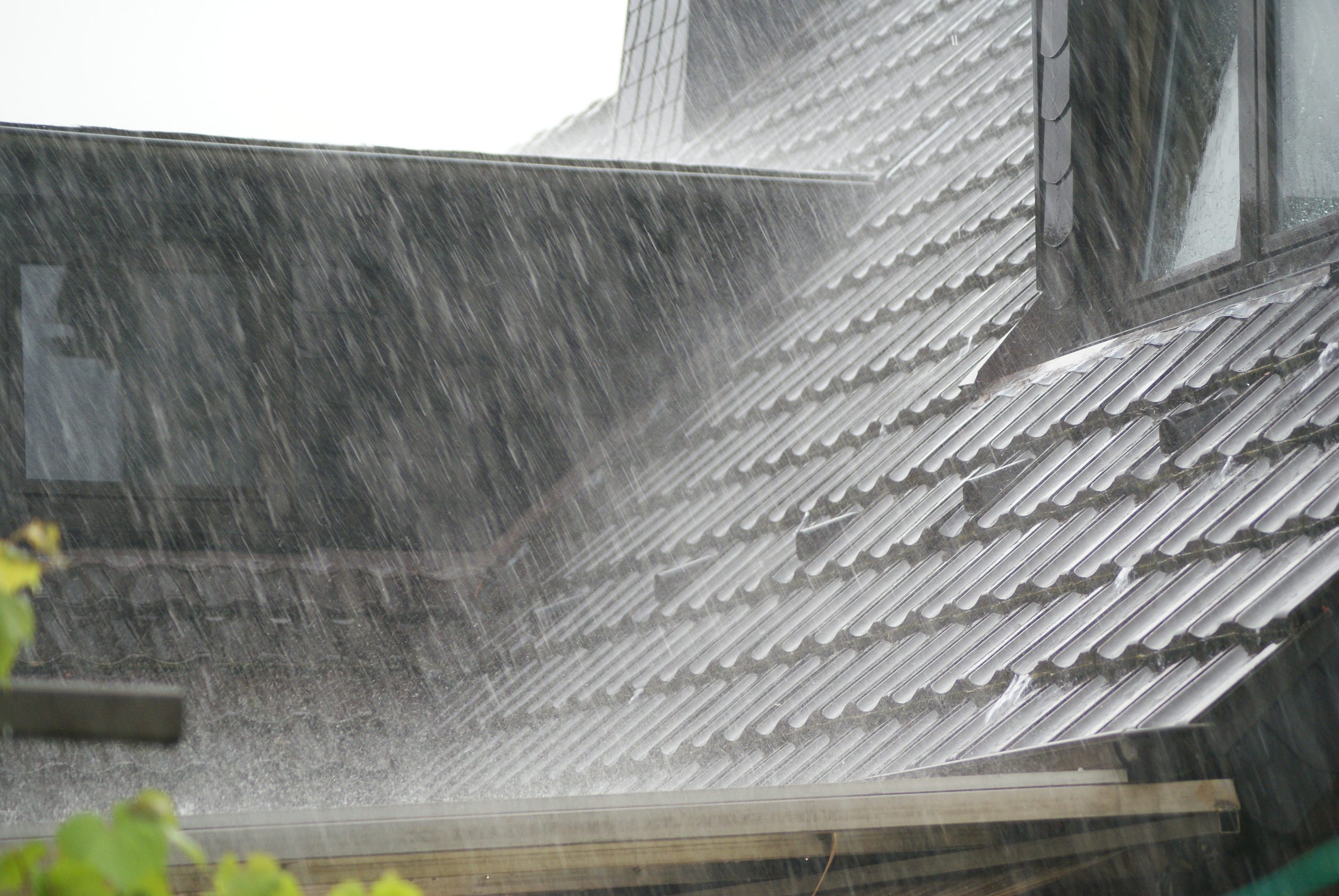 Rain and hail on black tile roof
