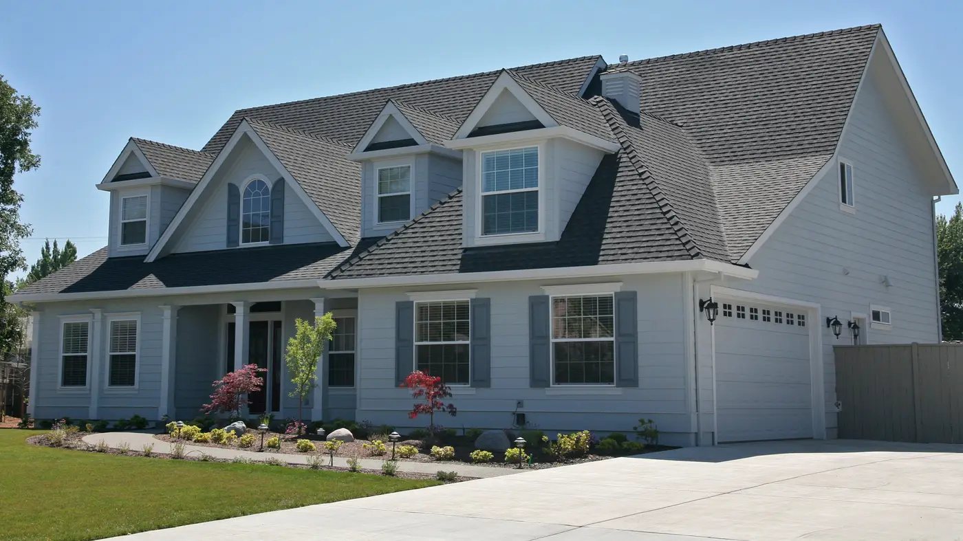 A house with white siding and a black roof in Mechanicsburg, PA, by Joyland Roofing.