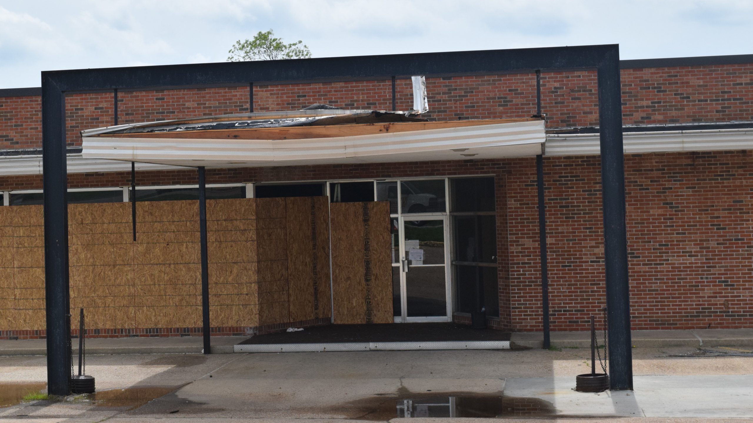 The front of a building with partial roof damage in the front in Mechanicsburg