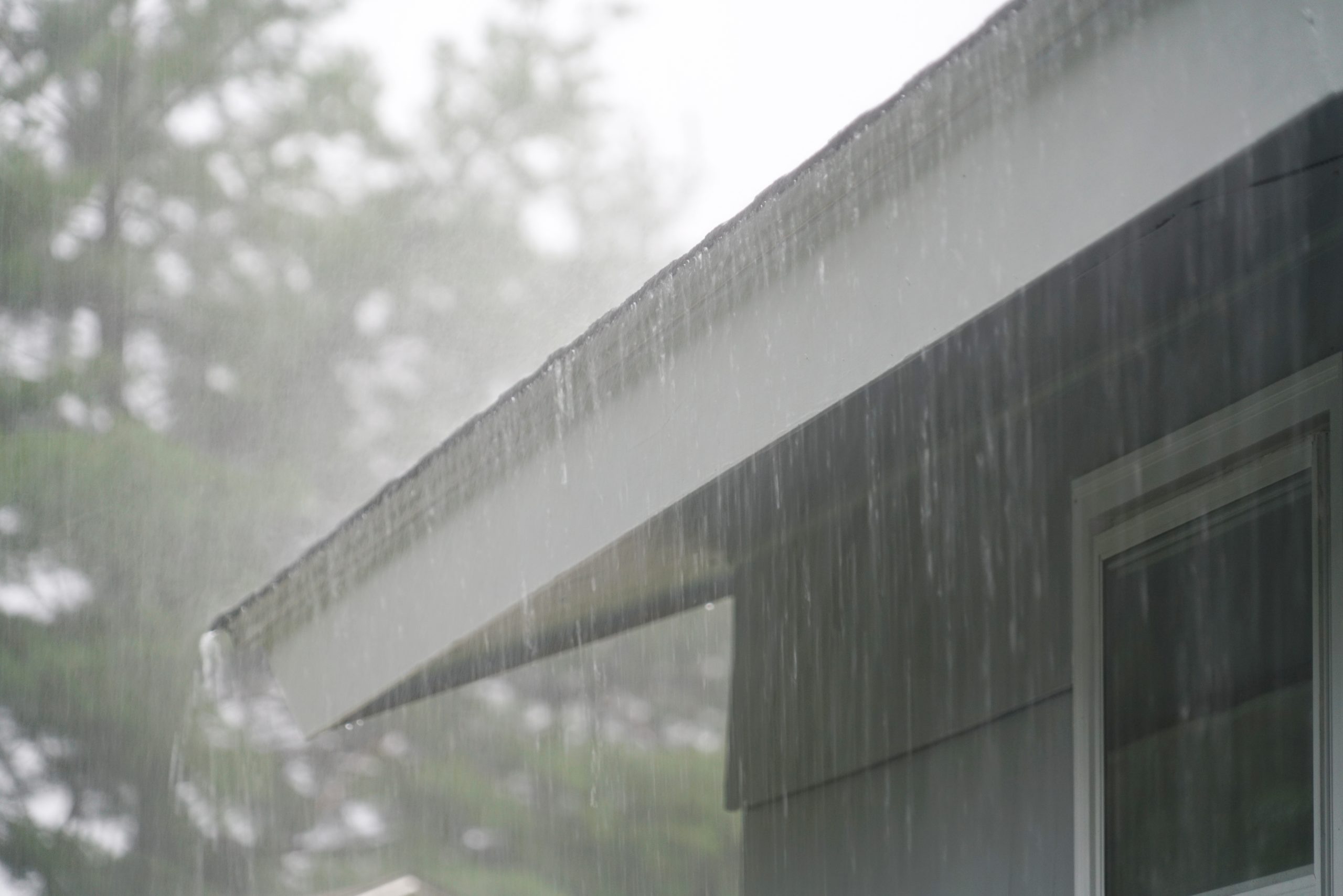 Close up of asphalt shingle roof in heavy downpour