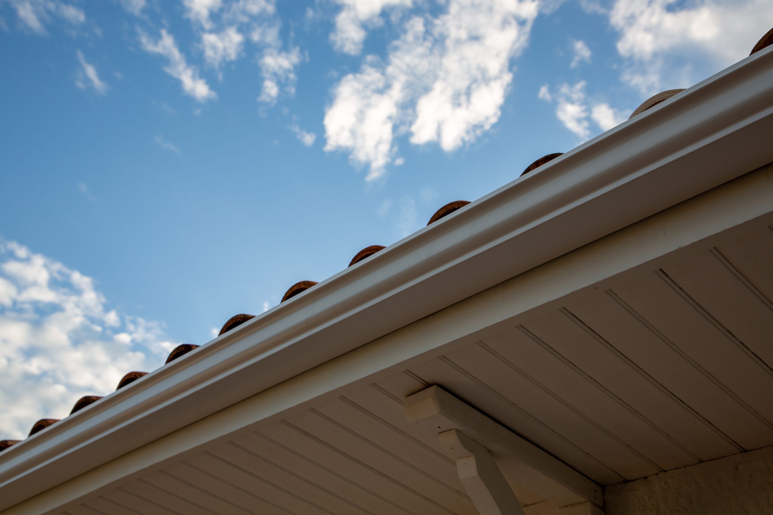 Close-up of seamless gutters against blue sky with clouds